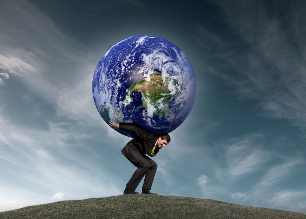 Man in a suit contemplating business debt consolidation and hunched over, carrying the world on his back.